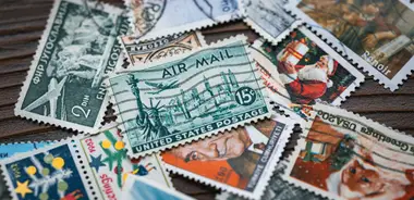 A collection of vintage postage stamps on a wooden surface