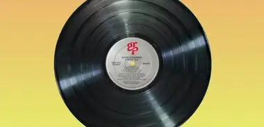 A black vinyl record on an orange surface
